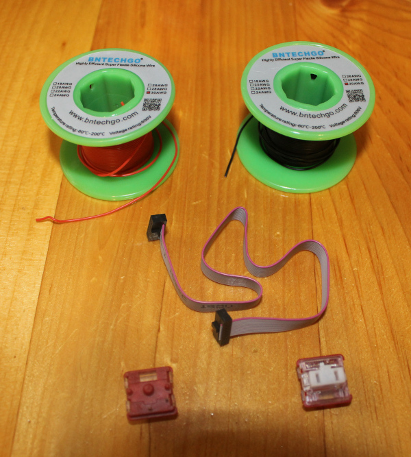 Supplies needed to convert Glove80 to Glove82.  Some 30 AWG wire, a 2x6 1.27mm ribbon cable, and two Kailh Low Profile Choc switches.